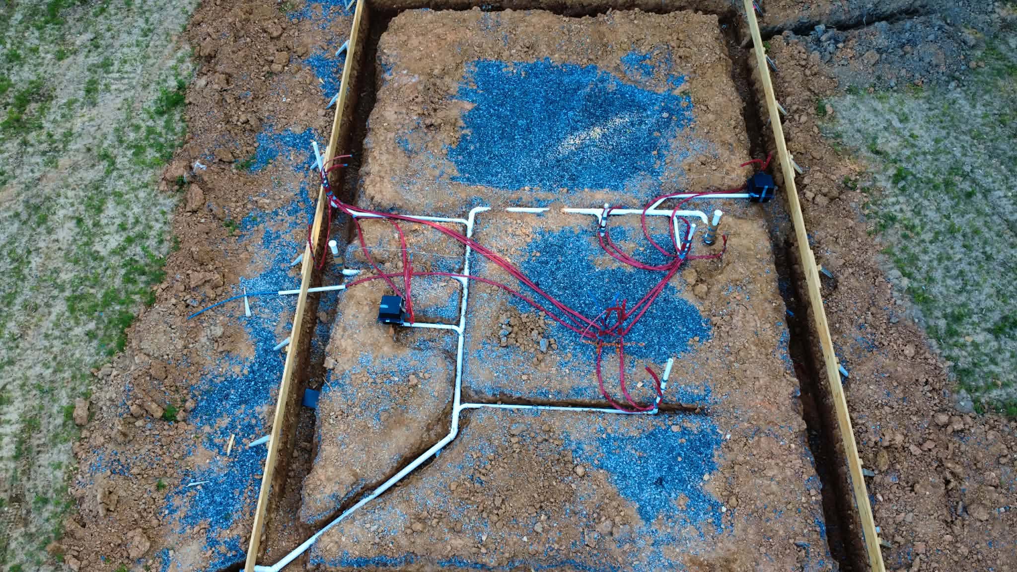 Aerial view of foundation plumbing rough-ins for new home construction